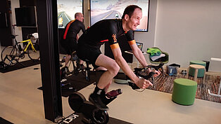 Michael Zgoll und seine Mitarbeiter fahren auf Trainingsrädern eine virtuelle Fahrradtour.