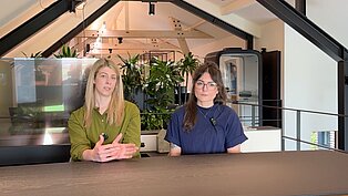 amara und Charlotte im Gespräch über die Planung und Konzeption von Arbeitsflächen für neue Bürolandschaften